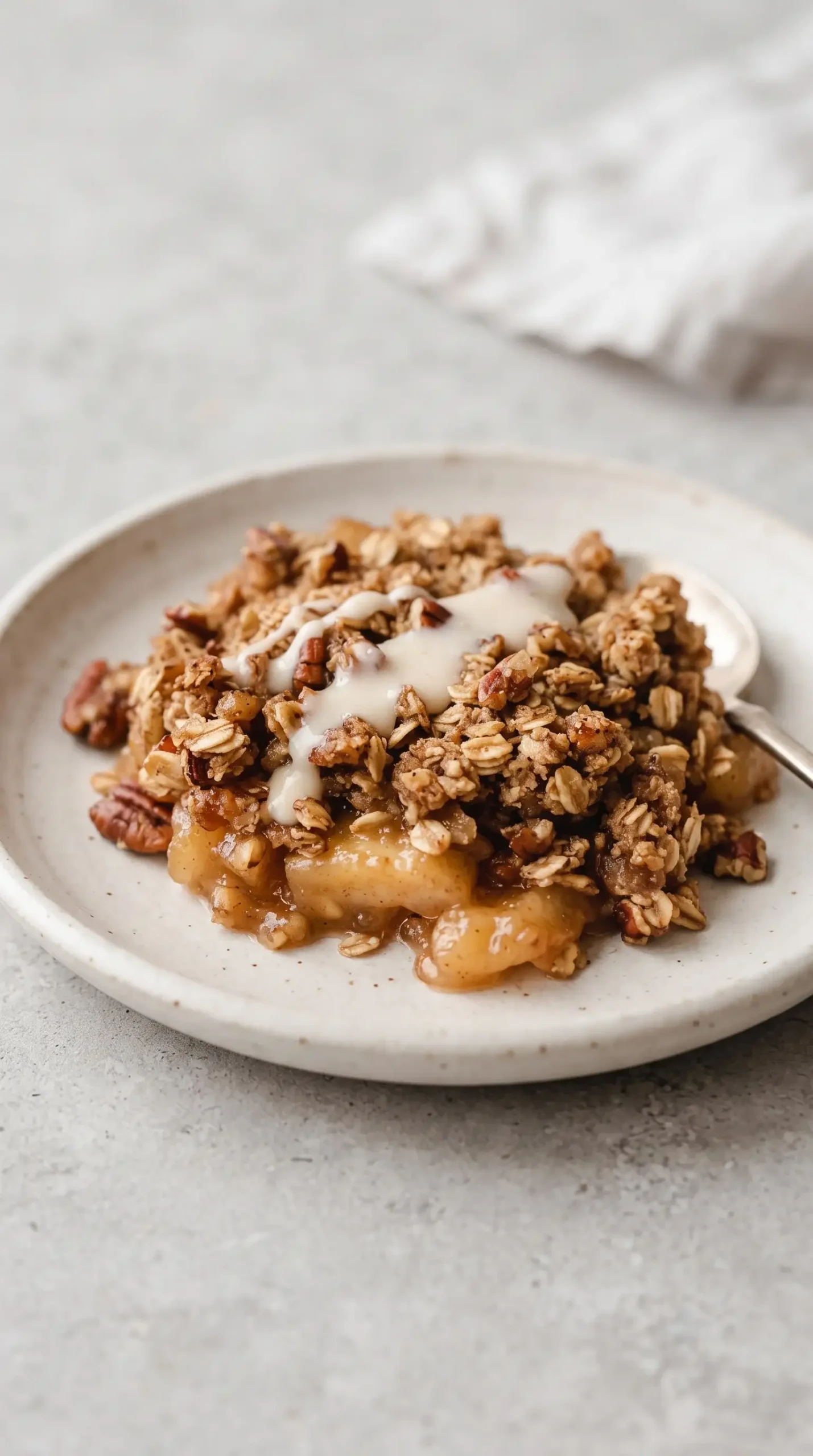 Serving of apple crisp with browned oat topping and honey goat cheese drizzle