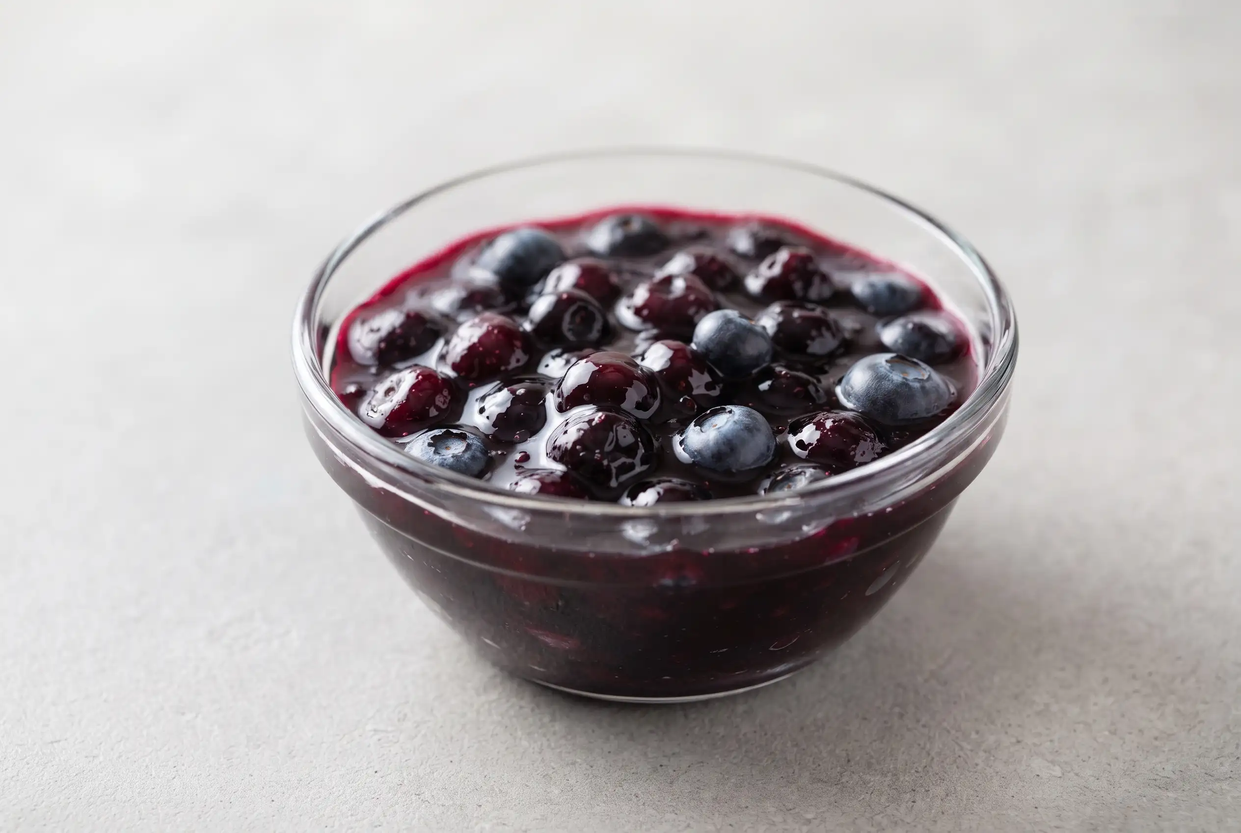 Blueberry sauce with fresh blueberries and vanilla in a glass bowl with a thick glossy texture
