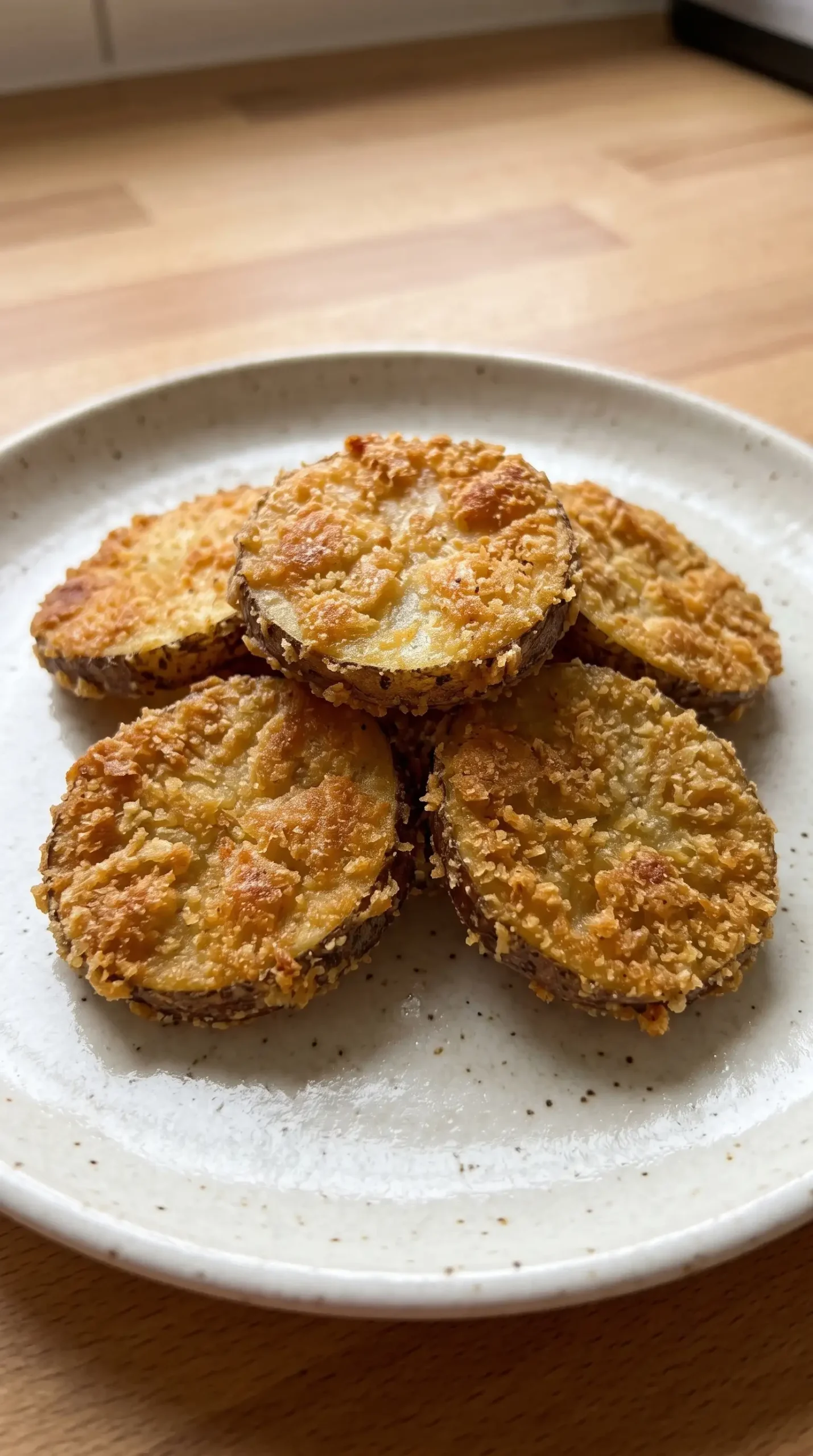 Thin crispy potato mojos showing golden breaded coating and fried potato slice texture