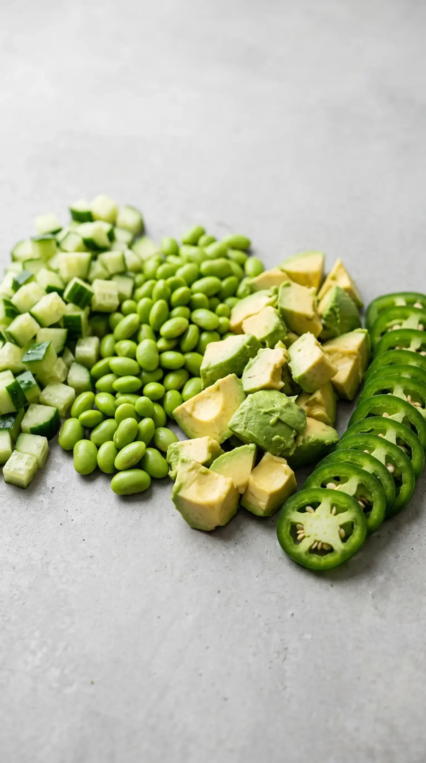 Fresh cucumber, edamame, avocado, and jalapeño toppings for crunchy roll bowls