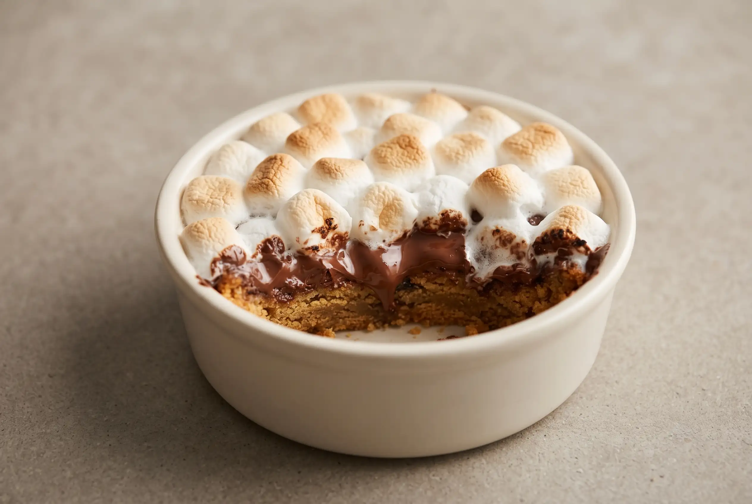Deep dish s mores bowl with graham crust, melted chocolate, and toasted mini marshmallows