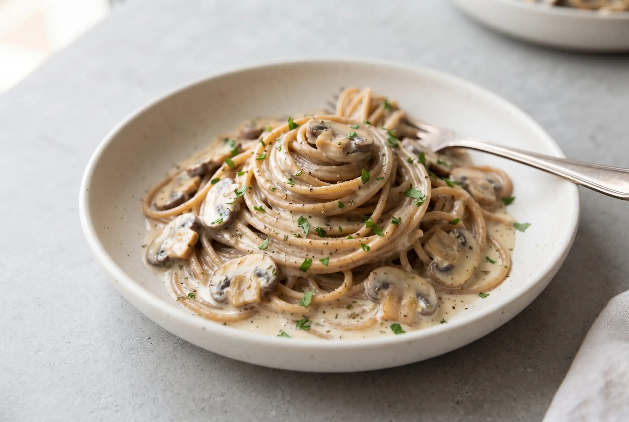 Garlic herb mushroom spaghetti with creamy herb sauce, mushrooms, and parsley on a plate