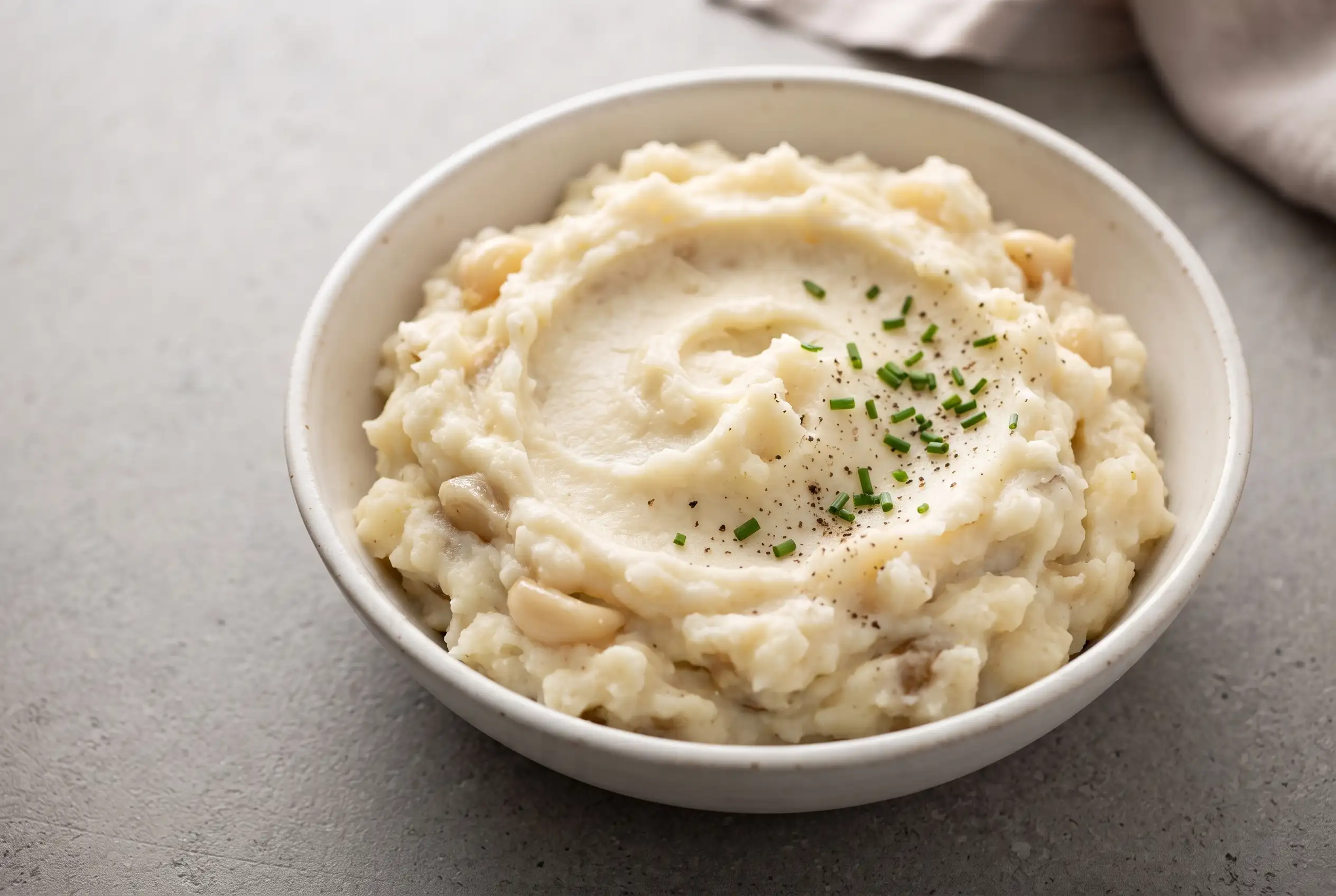Creamy garlic mashed potatoes with sour cream in a ceramic bowl