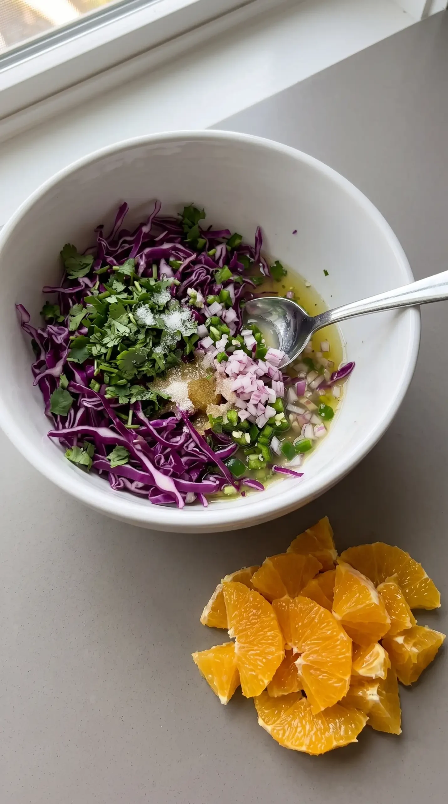 Orange salsa ingredients with cabbage, cilantro, onion, and citrus prepared in a bowl