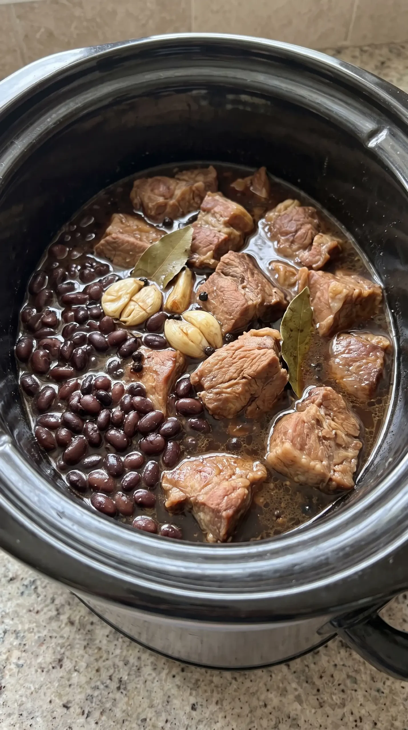 Slow cooker pork adobo with pork shoulder, black beans, garlic, and savory sauce