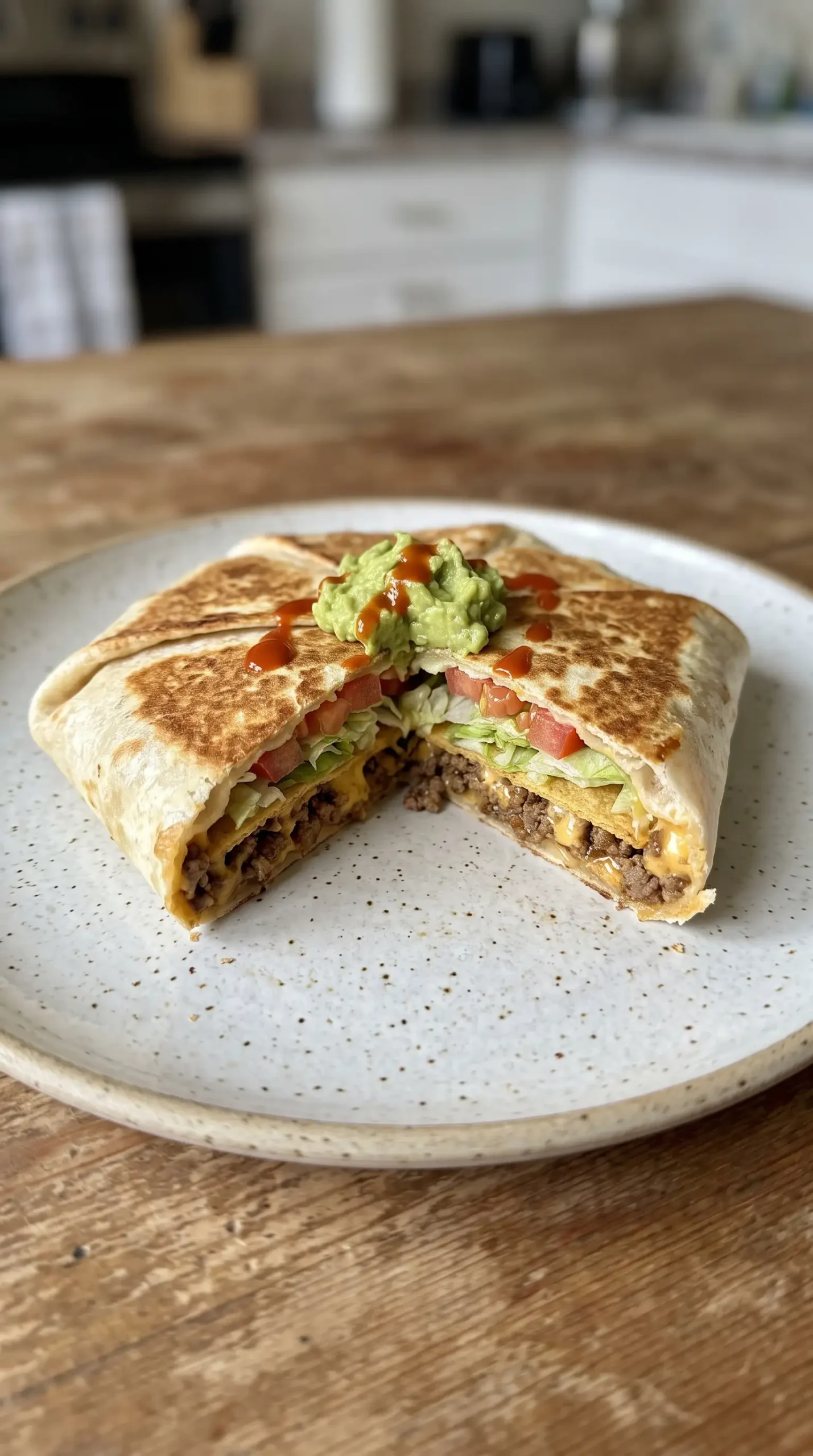 Toasted Crunchwrap Supreme with beef, queso, and crisp layers visible inside